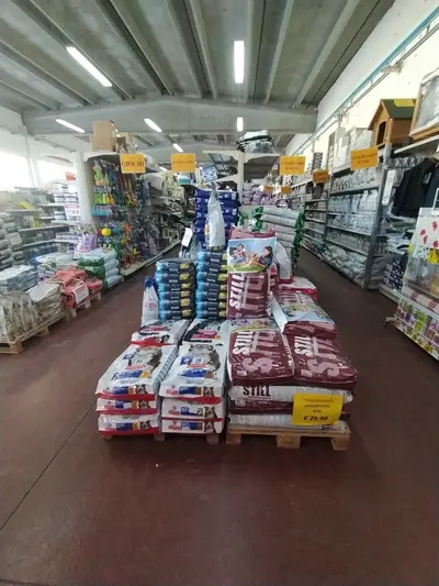 Bancali di mangimi e prodotti per animali esposti nel reparto pet shop di Green Service Oulx