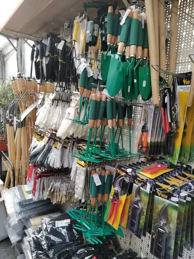Scaffale con attrezzi da giardinaggio, guanti e forbici esposti nel reparto brico-agraria di Green Service Oulx